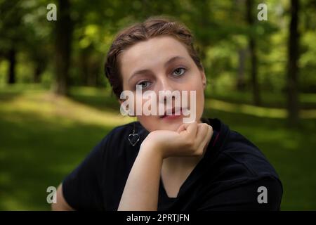 young woman thinking leaning on her chin outside student portrait Stock Photo