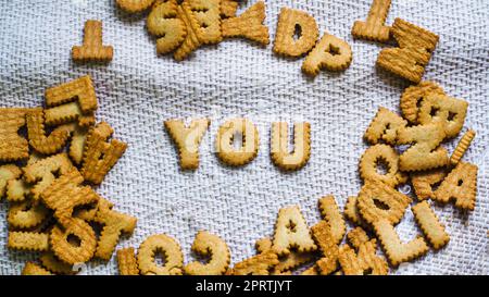 find you concept Cookies in the form of the alphabet prospect .Happy from homemade cookies on dark white background. Happy cookies concept. Stock Photo
