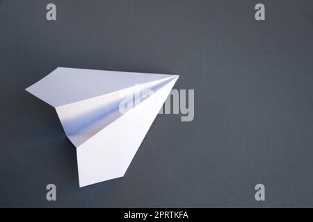 White paper plane origami isolated on a grey background Stock Photo