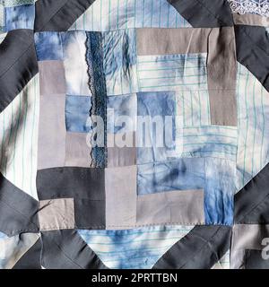 detail of hand-stitched patchwork quilt from pieces of various silk fabrics sewn in convergence technique Stock Photo