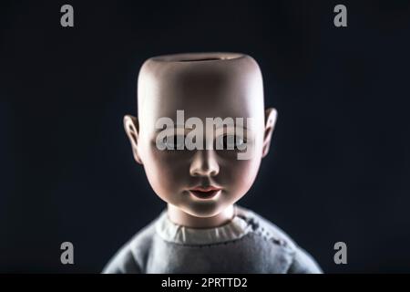 Creepy doll face on dark background Stock Photo