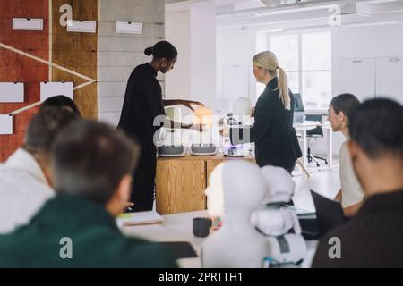 Mature female teacher explaining student over social robot in innovation lab Stock Photo