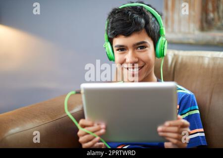 I can watch movies wherever. Portrait of a little boy watching a video on his tablet. Stock Photo