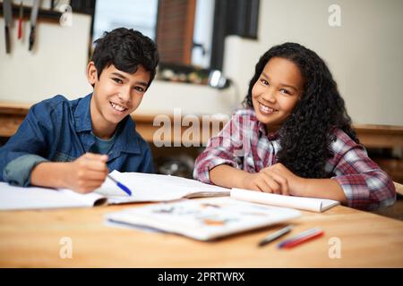 Study buddies make homework easier. two young students studying together in a classroom. Stock Photo