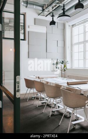 Chairs and tables arranged in empty meeting room at office Stock Photo