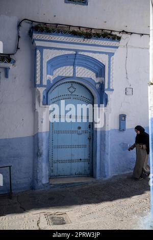 Figure of a woman walking through the streets of Chefchaouen. Stock Photo