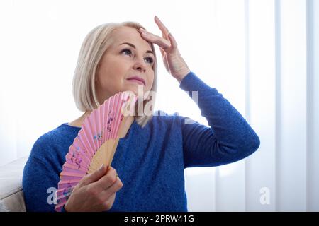 Mature woman experiencing hot flush from menopause Stock Photo