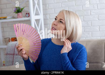 Mature woman experiencing hot flush from menopause Stock Photo