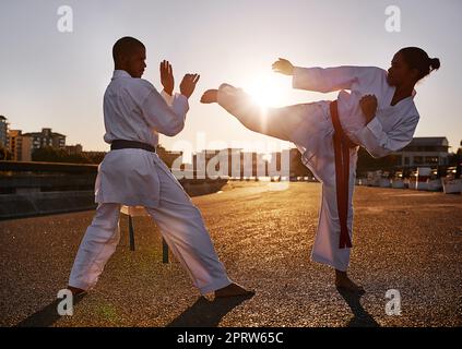 Blocked. Two sportspeople facing off and practicing their karate while wearing gi. Stock Photo