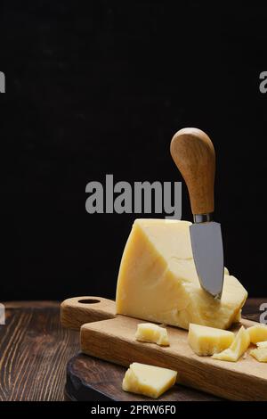 Parmesan cheese on wooden cutting board Stock Photo