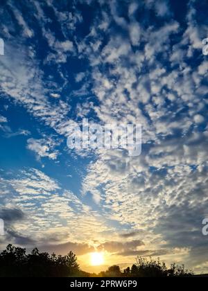 Beautiful fluffy white cloud formations in a deep blue summer sky Stock Photo