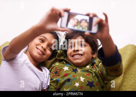 Sibling selfies. two siblings taking a photo of themselves at home. Stock Photo