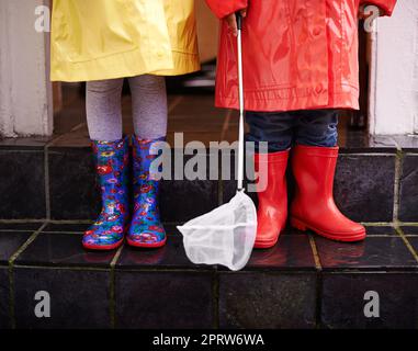 Ready for the rain. two children dressed in raincoats and galoshes. Stock Photo