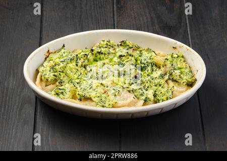 Meat dumplings with spinach and cheese sauce baked in oven Stock Photo