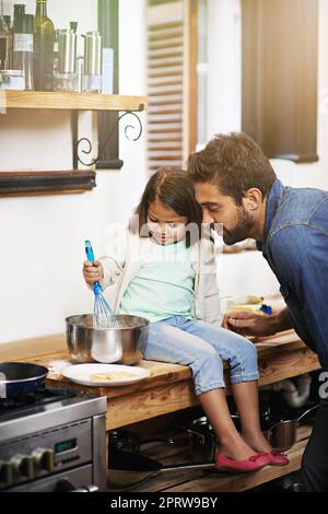 Culinary cuteness. a father and daughter making pancakes together. Stock Photo