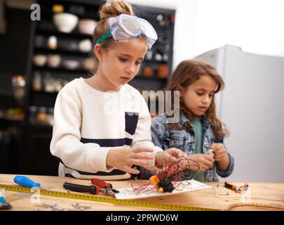 Creative kids at work. a two little girls pretending to be construction workers at home. Stock Photo