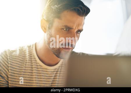 Inbox overflowing... time to get some emails out of the way. a young man working on his laptop in a coffee shop. Stock Photo