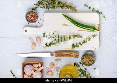 Top view of wooden cutting board with fresh thyme and spices for piquant sauce or marinade Stock Photo