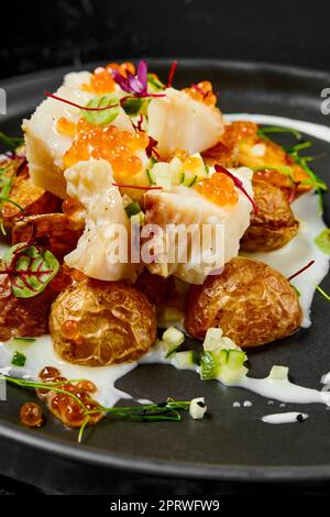 Roasted cod fillet with fried spring potato Stock Photo