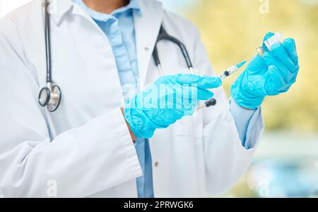 Covid vaccine, injection and corona virus medicine with needle, vial and syringe from hospital doctor. Closeup hands, healthcare worker and flu jab, antiviral shot and medical treatment for immunity Stock Photo