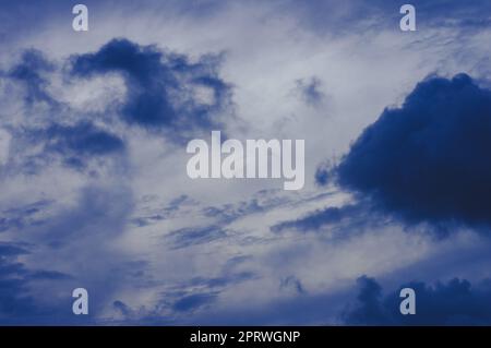 Dark clouds in blue sky background. Dark Rain clouds floating in sunset sky. Nature background. Stock Photo