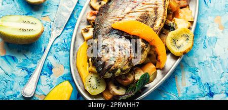 Baked grilled fish in fruit. Stock Photo
