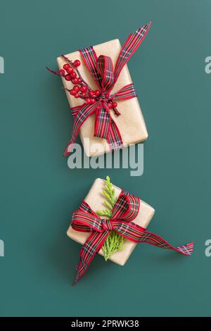 Gift boxes wrapped in karft paper with red ribbon bow on green top view Stock Photo