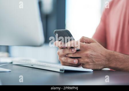 Smart tech is a must for a search engine specialist. a businessman using a smartphone at his desk in a modern office. Stock Photo