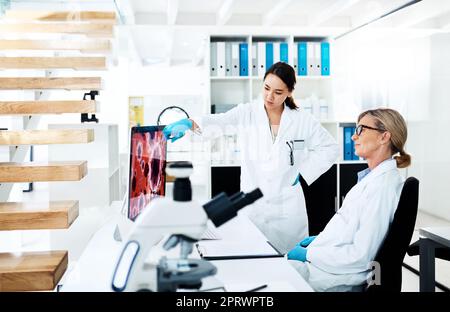 Clinical research helps translate medical discoveries into working treatments. two scientists working together on a computer in a lab. Stock Photo