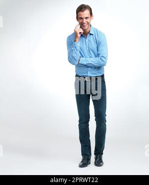 Let me think about it. a handsome young man standing in a studio. Stock Photo