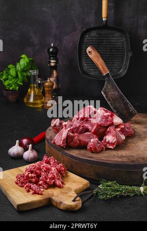 Chopping fresh beef meat on wooden chopping stump Stock Photo