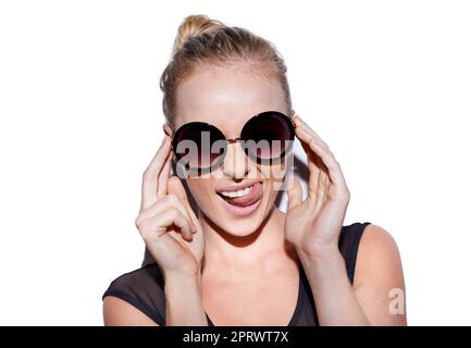 Shes a spunky girl. Portrait of an attractive young woman with sunglasses posing playfully in studio. Stock Photo