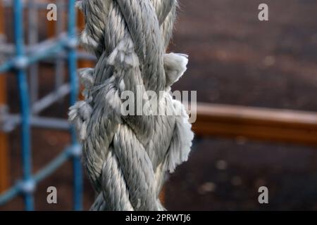 Worn gray rope close-up on a children's playground in a city park Stock Photo