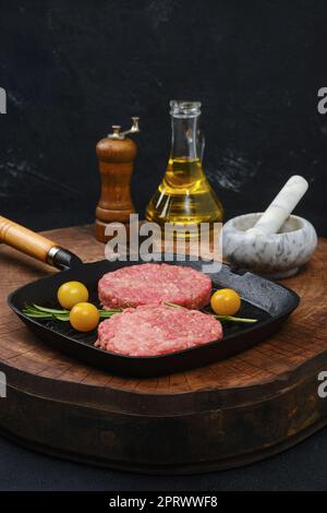 Raw beef burger patty on frying pan Stock Photo
