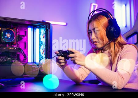 Woman wear gaming headphones playing live stream esports games console Stock Photo