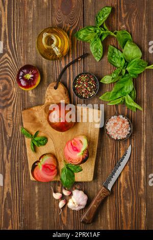 Fresh meaty tomato on wooden cutting board Stock Photo