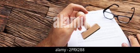 Businessman Stamping Contract Paper At Table Stock Photo