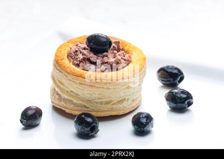 puff pastry filled with terrine served with black olives Stock Photo