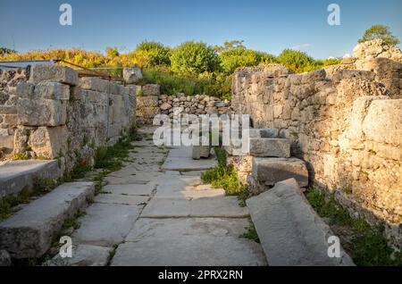 The remains of a narrow lane with an entrance to a Peristyle house  at the ancient Roman city at Side in Antalya Province, Turkey (Turkiye). The ruins Stock Photo