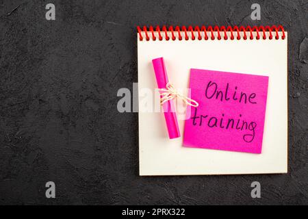 top view online training written on pink sticky note on notepad on black table copy place Stock Photo