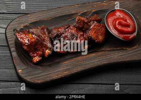 Barbecue spare ribs and BBQ sauce on wooden board Stock Photo