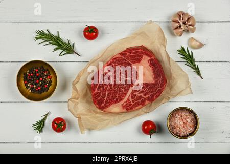 Close up raw beef ribeye steak on paper Stock Photo