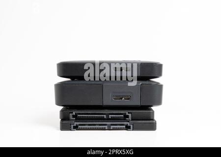 A stack of external USB hard drives on a white background. Stock Photo
