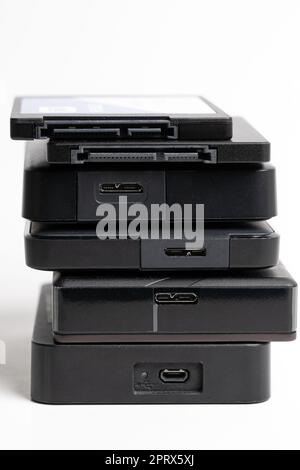A stack of external USB hard drives on a white background. Stock Photo