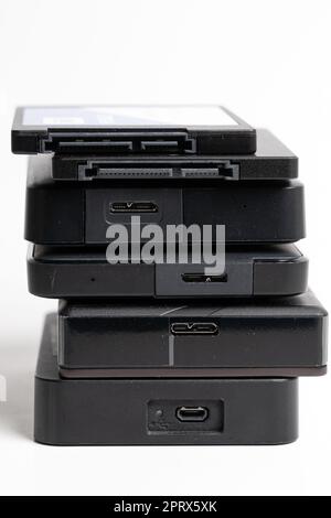 A stack of external USB hard drives on a white background. Stock Photo