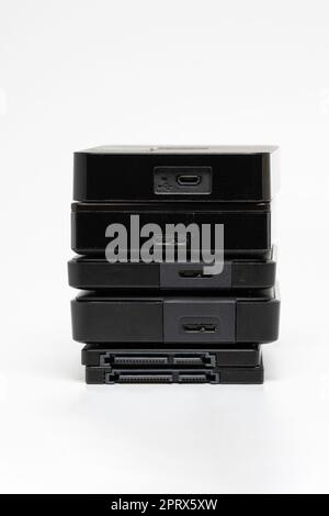 A stack of external USB hard drives on a white background. Stock Photo