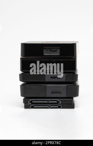 A stack of external USB hard drives on a white background. Stock Photo