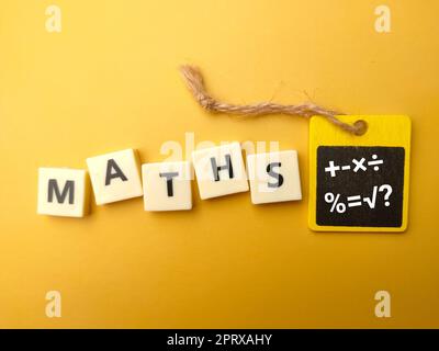 Toys word with the word MATHS with symbol of maths on yellow background. Education concept. Stock Photo