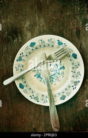 vintage plate on a rustic wood table, with fork and knife Stock Photo