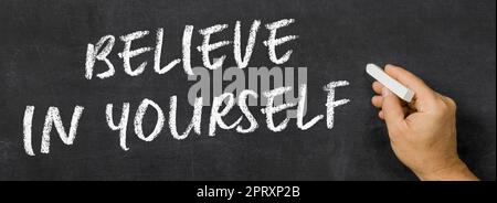 Text written on a blackboard -  Believe in yourself Stock Photo